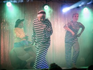 Scène de danse avec des personnages comiques lors d'un spectacle Arbre de Noël, animation festive et interactive pour enfants