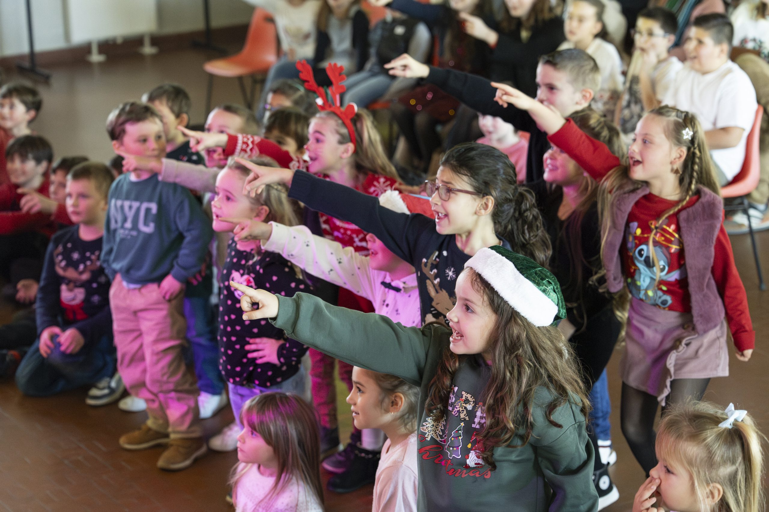 Enfants participant avec enthousiasme au spectacle Arbre de Noël lors d'animation de Noël en salle