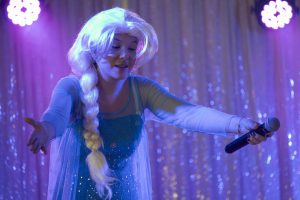 Artiste en costume de reine des neiges chantant lors d'un spectacle Arbre de Noël, animation musicale féerique pour enfants